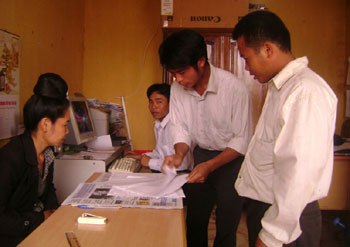 Cán bộ văn phòng Phòng “một cửa” thị trấn Điện Biên Đông hướng dẫn người dân làm thủ tục chứng thực học bạ. Ảnh: Đ.T