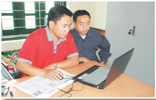 Cán bộ xã Pu Nhi trao đổi sử dụng máy vi tính.