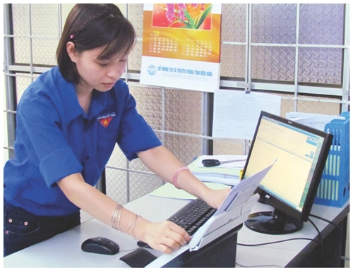 Nhân viên bộ phận “một cửa” Sở TT&TT tiếp nhận hồ sơ và quét lên mạng eoffice  Ảnh: PV  Kim Thu