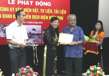 Đồng chí Giàng Thị Hoa, Tỉnh ủy viên, Phó Chủ tịch UBND tỉnh Điện Biên tiếp nhận kỷ vật trao tặng tại lễ phát động. Ảnh: P.V