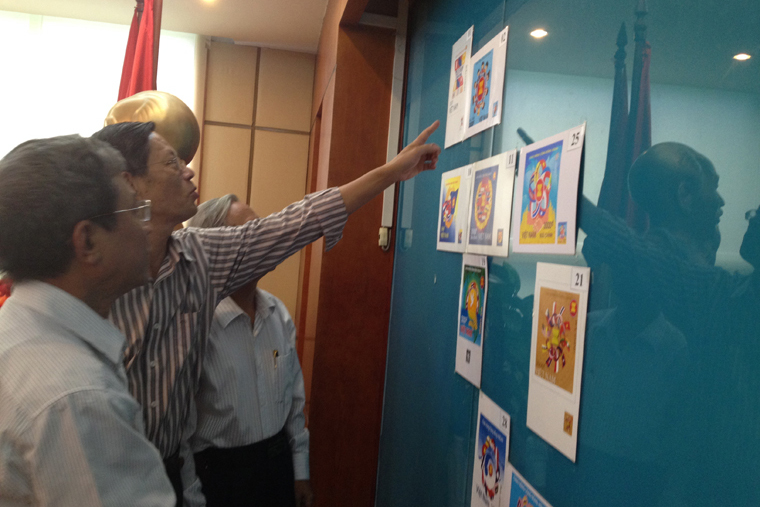 Các thành viên hội đồng chấm thi đánh giá các mẫu tem.