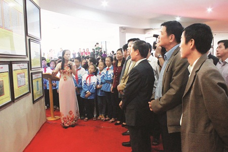Lãnh đạo Bộ TT&TT, lãnh đạo tỉnh Điện Biên và các em học sinh tham quan Triển lãm bản đồ và trưng bày tư liệu Hoàng Sa, Trường Sa là của Việt Nam tại tỉnh Điện Biên sau Lễ khai mạc.